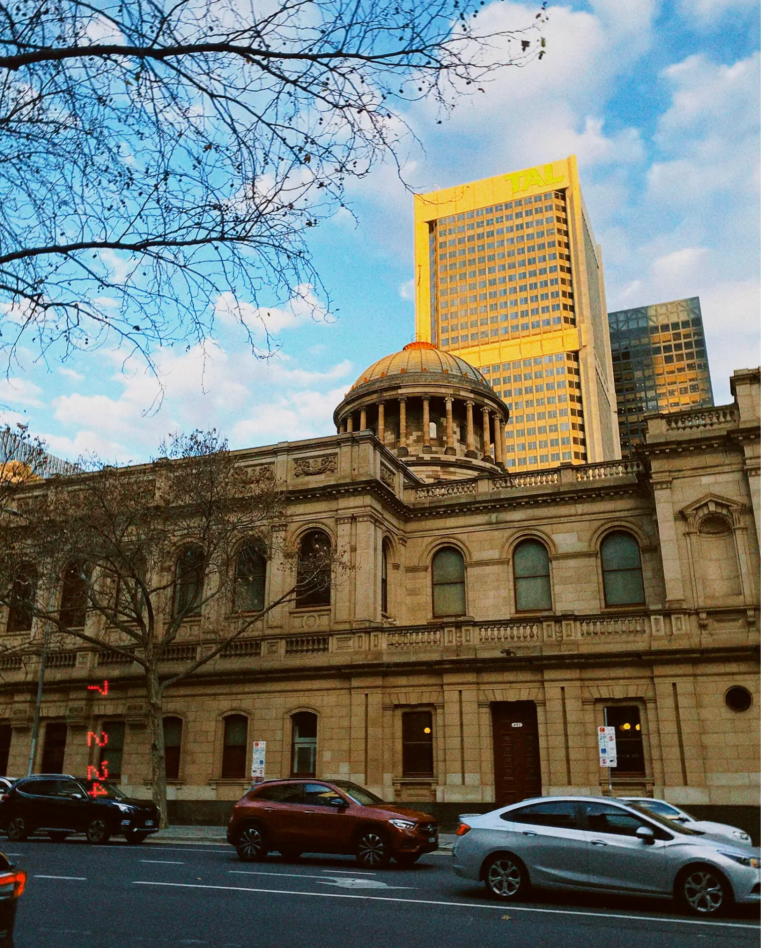 Historic sandstone dome alongside modern high-rise towers in golden light