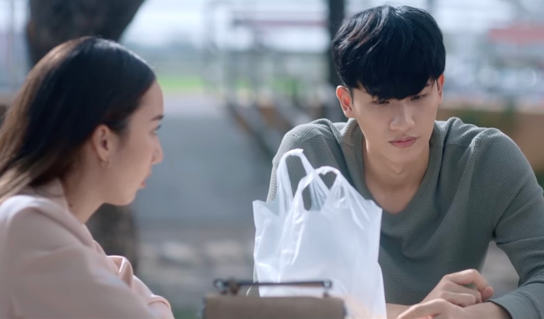 Good Old Days series still — two characters talking at a café table