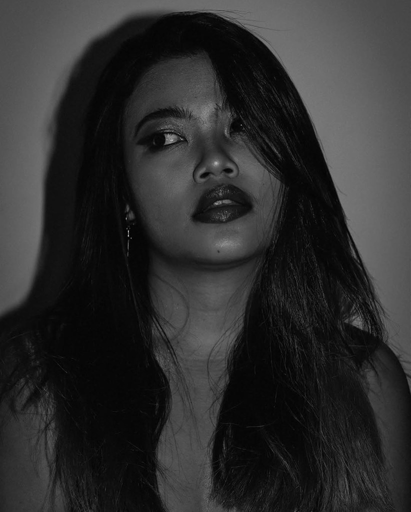 Moody low-light portrait of a woman with red lipstick
