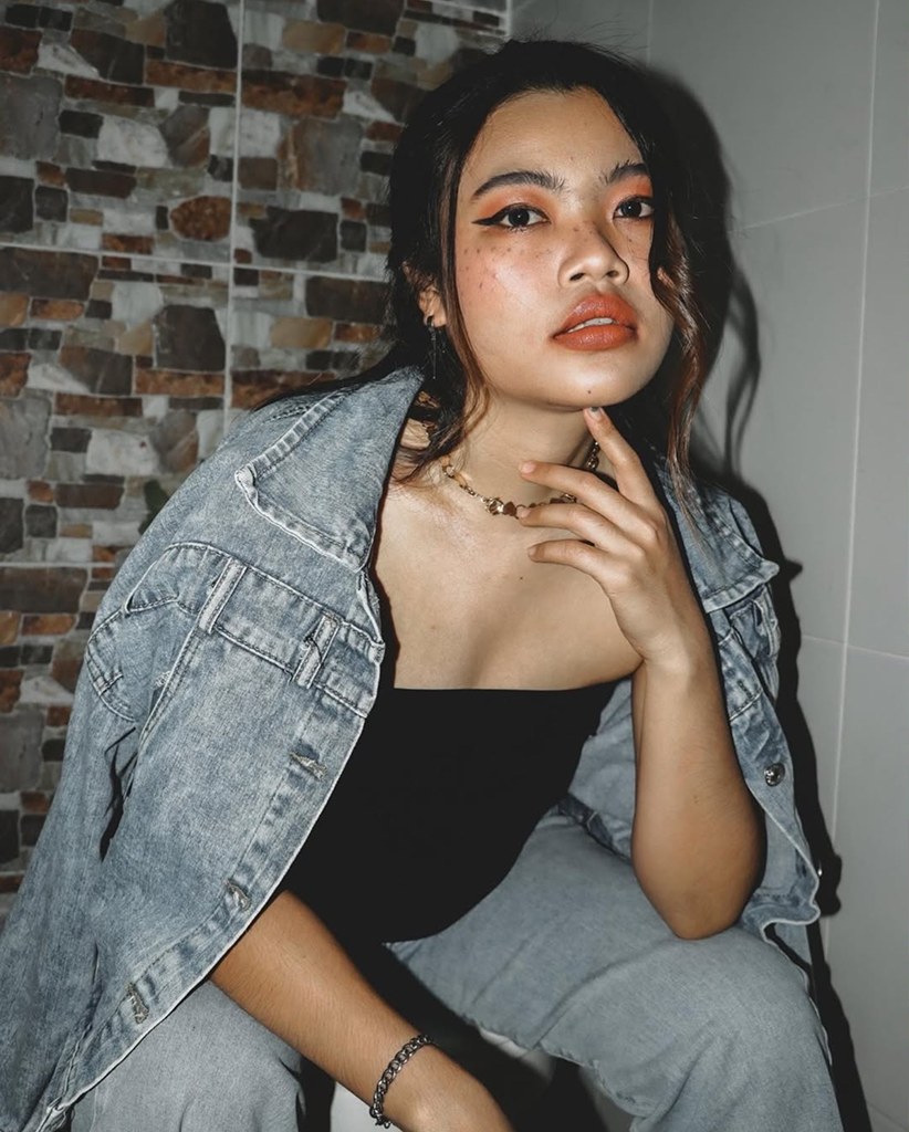 Woman in a denim jacket sitting outdoors