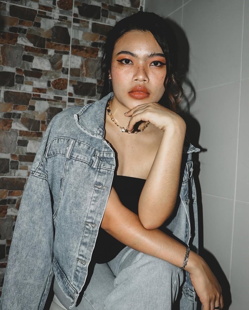 Woman in a denim jacket resting her chin on her hand