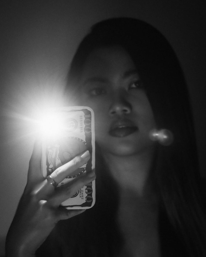 Woman holding a phone light close to her face in the dark