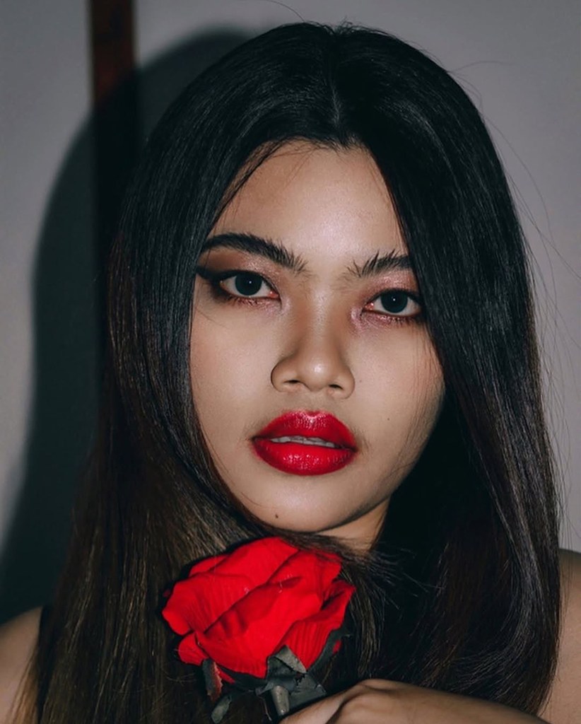 Portrait with a red rose beside her face